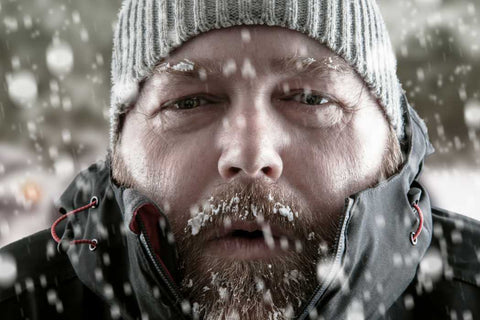 A bearded man wearing a grey toque fighting the cold showing signs of hypothermia