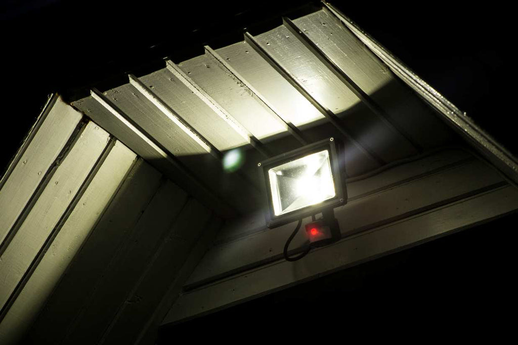 Solar powered security light at night attached to a house