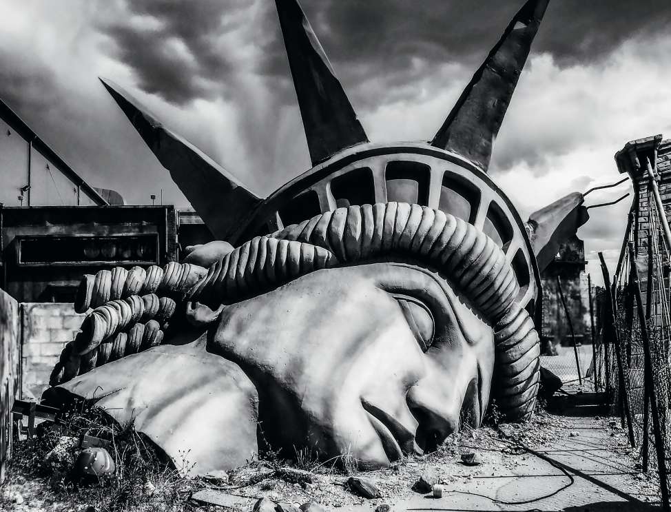 Head of the statue of liberty on the ground after a disaster