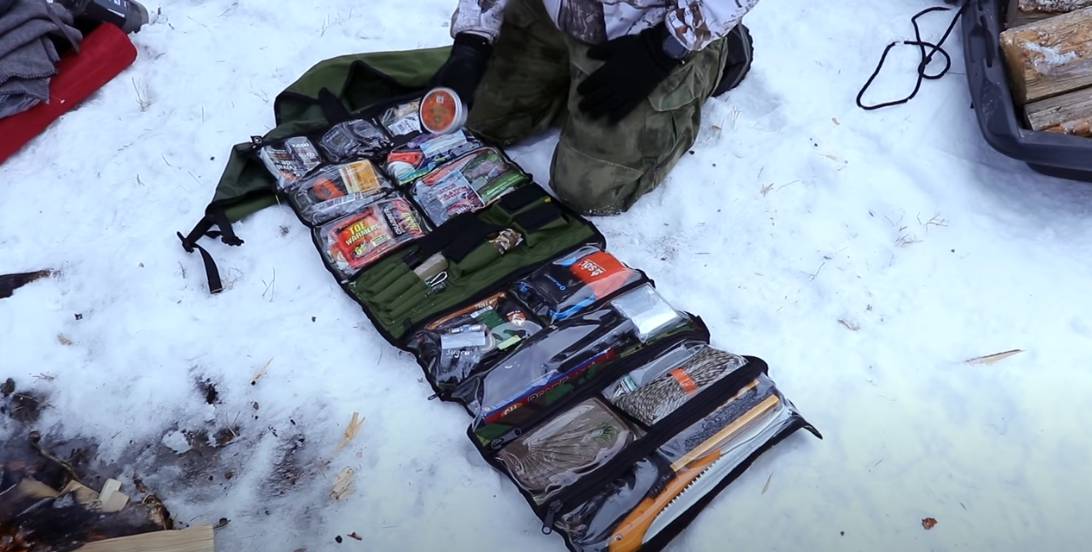 Winter bug out roll with various gear like: fat rope sticks, paracord, freeze dried food and other prepper gear