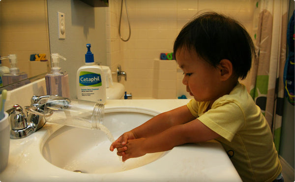 Next two steps are pretty self explanatory. Insert the rubber band and attach it to your faucet. And in the words of my hubby… you’re DONEZO!  Here’s the little monster in action using his new gadget made by his macgyver Daddy