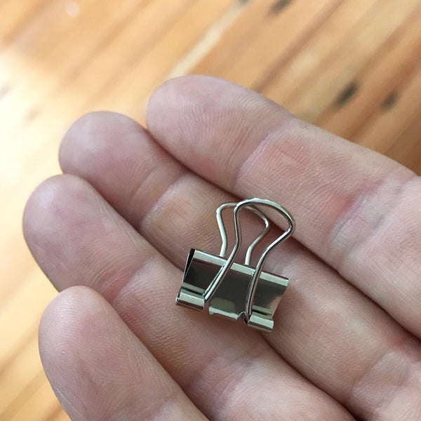 Hand holding silver binder clip