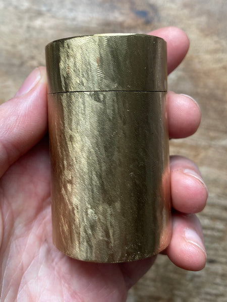 Brass container with file marks on surface