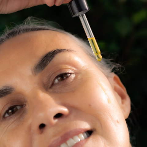 Image of woman applying skin oil