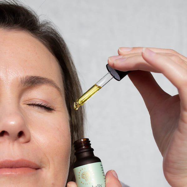 8 Surprising Mānuka Oil Uses You Might Not Know About image showing a woman with beautiful skin using Manuka Oil on her face.