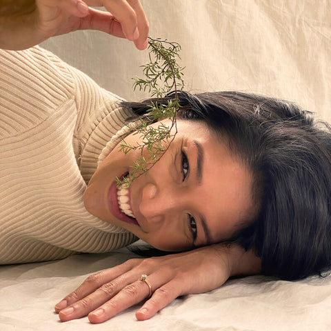 7 Ways To Be A More Mindful Consumer image showing a woman with Manuka plant near her face and smiling.