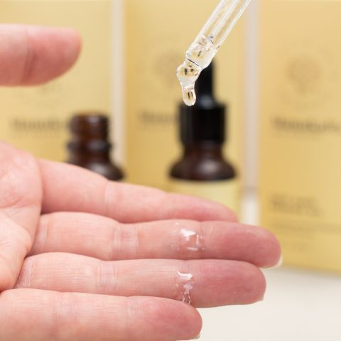 A drop of East Cape mānuka oil elegantly descending onto a hand, delivering its hydrating properties to nourish and moisturize the skin, capturing the essence of natural skincare and the soothing benefits of this precious oil.