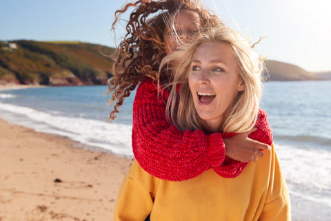 Natural Skincare: Why Going Natural is Key - Mother and daughter walking on a beach laughing and enjoying life.