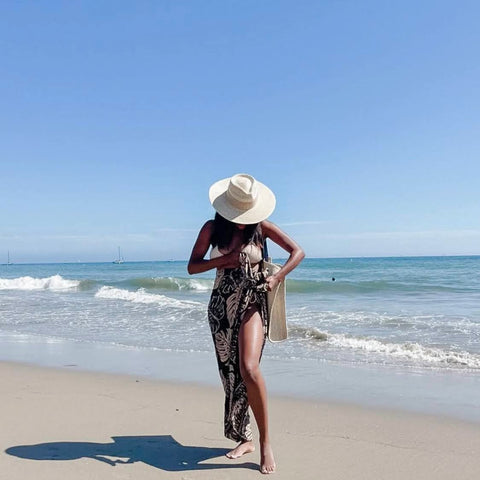 Räys by the Ocean founder and designer, Bria Robles, wearing her Monstera Dreams sarong, the Leah Bo Rancher palm straw hat and Luna straw tote bag