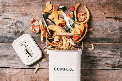 a kitchen compost caddy with food waste spilling out of it