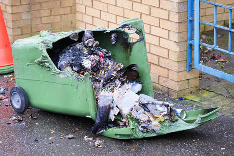 A green wheelie bin burnt after a fire