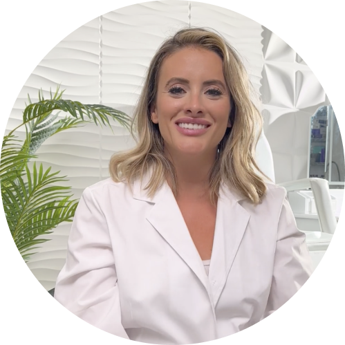 A professional woman in a white coat sitting in a modern, well-lit office.