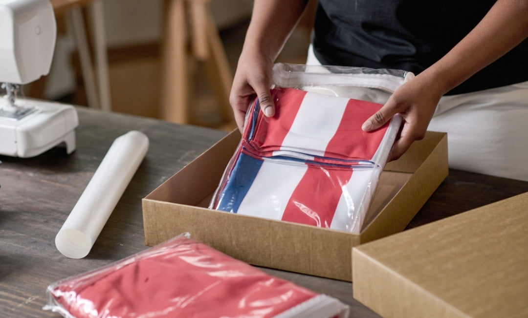 A woman packing a handmade American flag into a shipping box