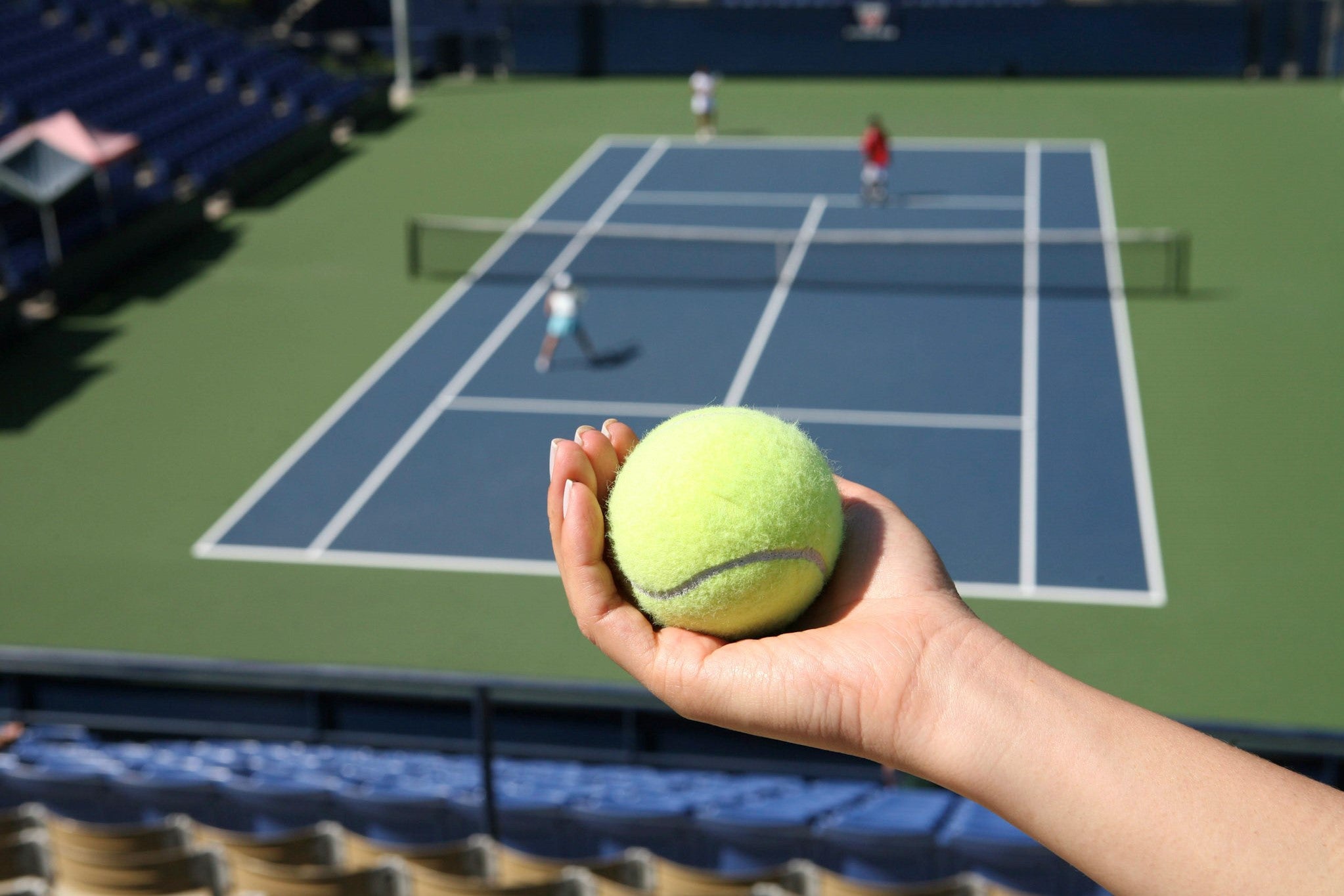 Fan in the stands with tennis ball in hand