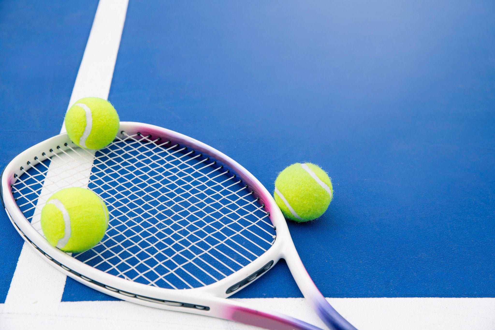 Tennis racquet and balls on the court