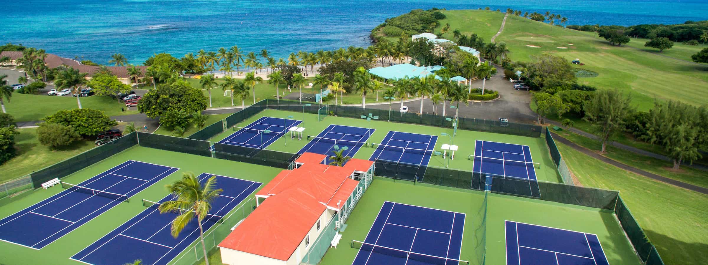 Striking blue tennis courts next to the caribbean sea