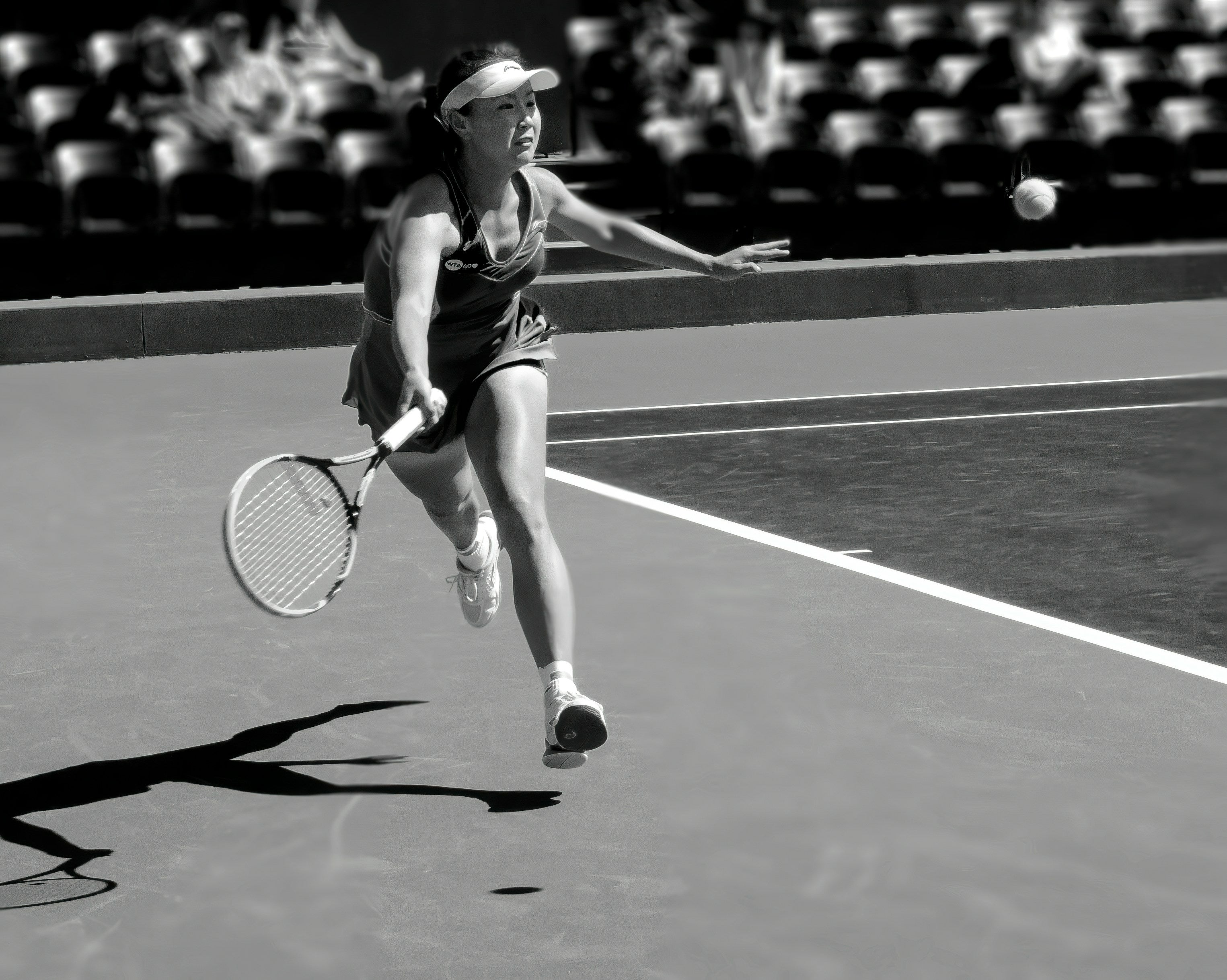 Woman running with racquet extended during tennis match