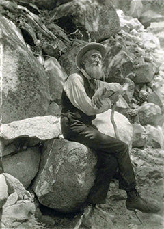 John Muir Sitting on Rocks