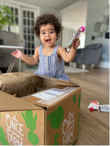 young girl excitedly opening a once upon a farm subscription box