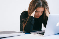 Woman looking stressed, starring at her laptop