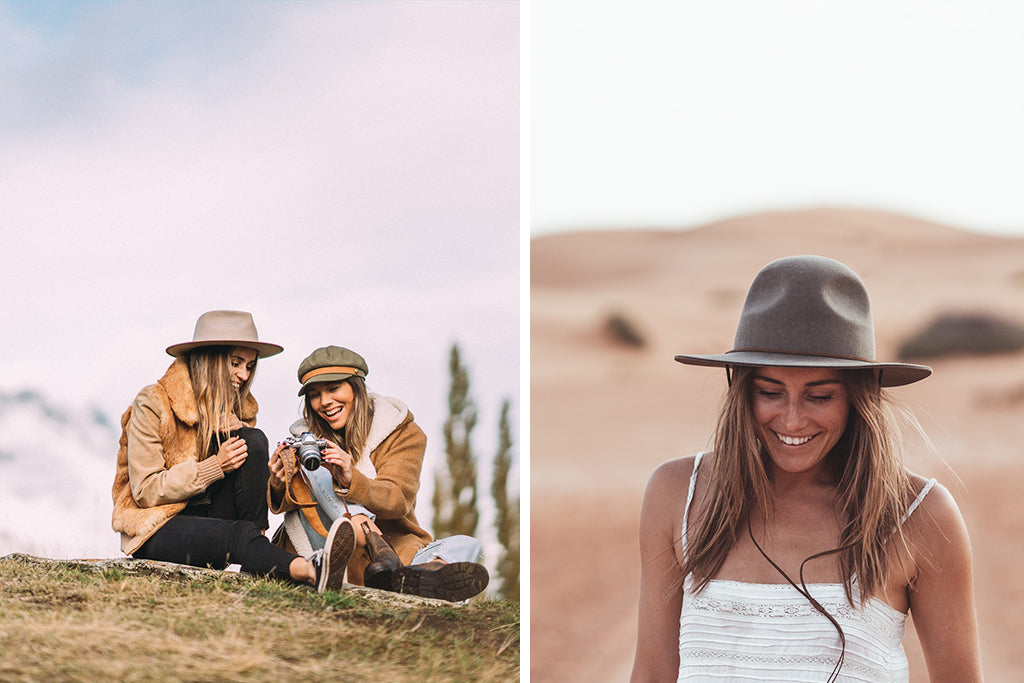 Lauren wearing Calloway Fawn and friend laugh whilst sit on grassy hill looking at images taken on their camera