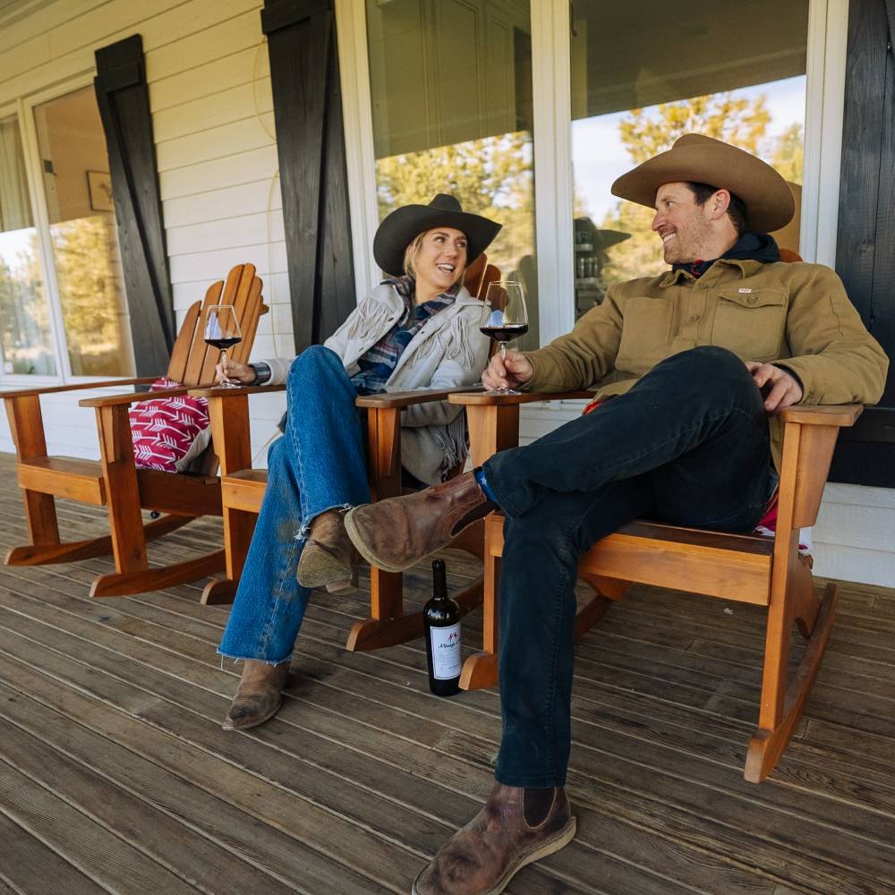 Man and woman wearing cowboy hats and drinking wine