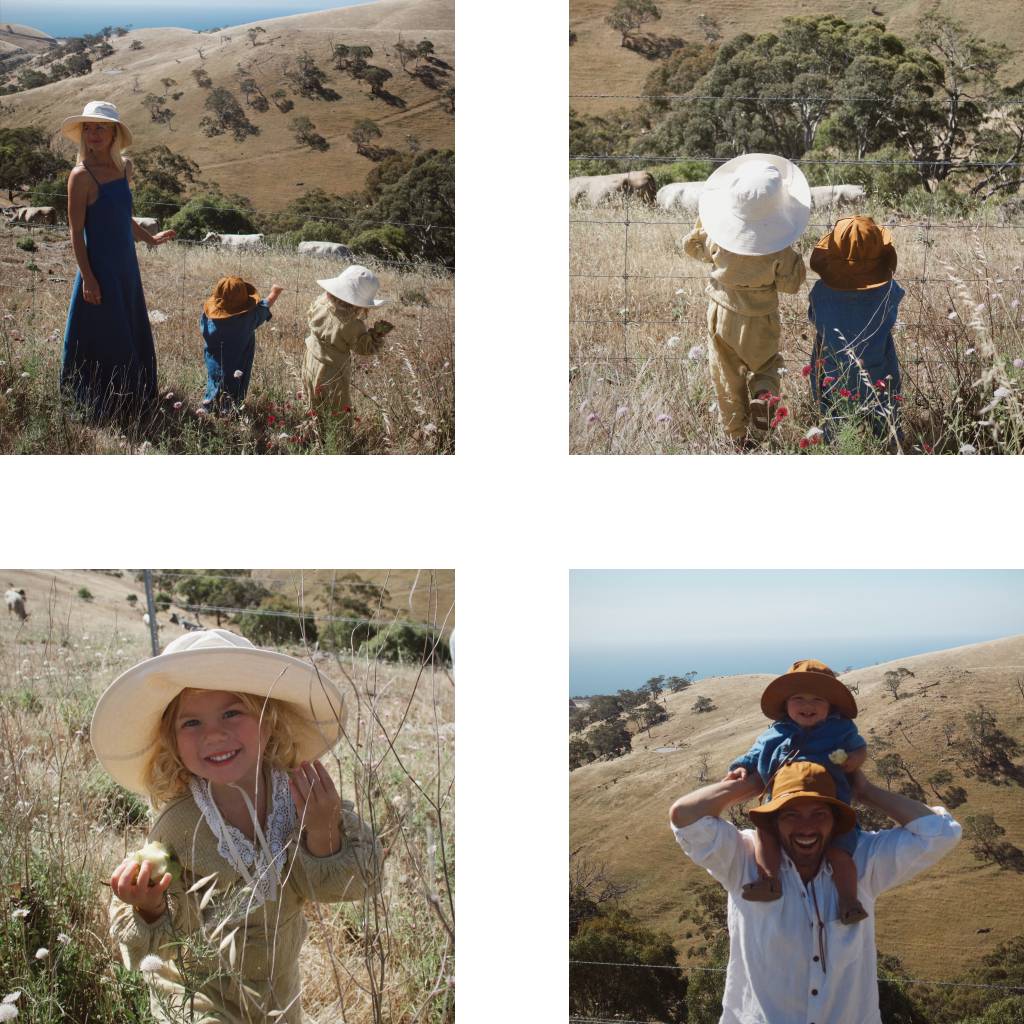 A young family on holiday wandering through a grassy field wearing bucket hats