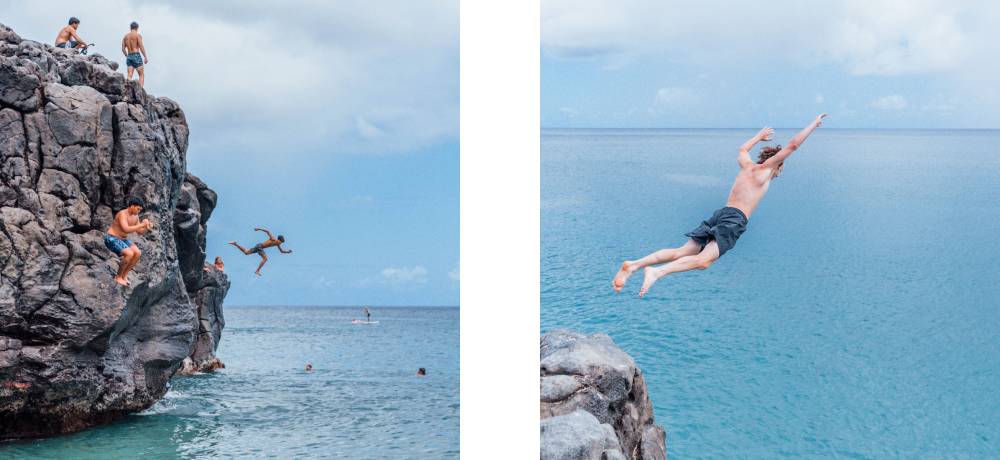 Kids jumping into the ocean off rocks on holiday in hawaii