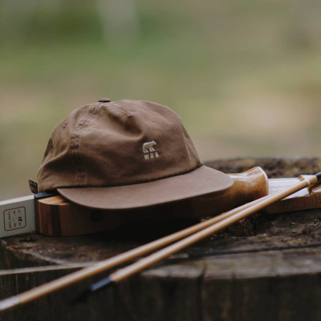 cap sitting on top of a piece of chopped wood outdoors