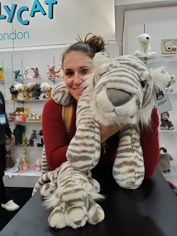 Devin at the New York Gift show snuggling a stuffed tiger, rocking her upcycled rubber adventure jewelry.
