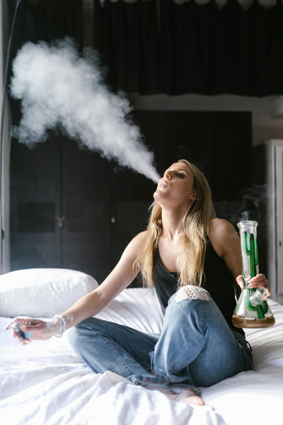 A young woman exhaling smoke from her ice water pipe