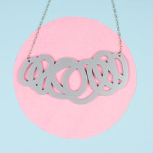 Load image into Gallery viewer, Chunky silver statement necklace on pink and blue background
