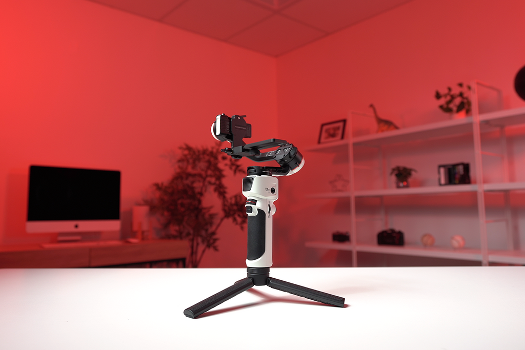 Gimbal placed on white desk with red background 