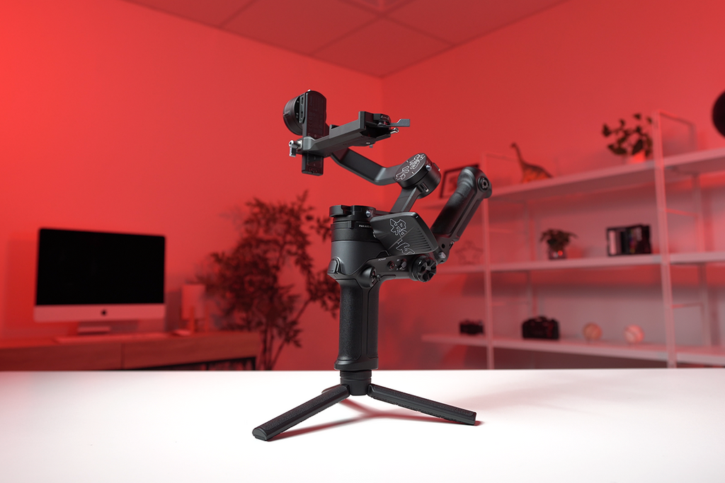 Gimbal placed on white desk with red background 