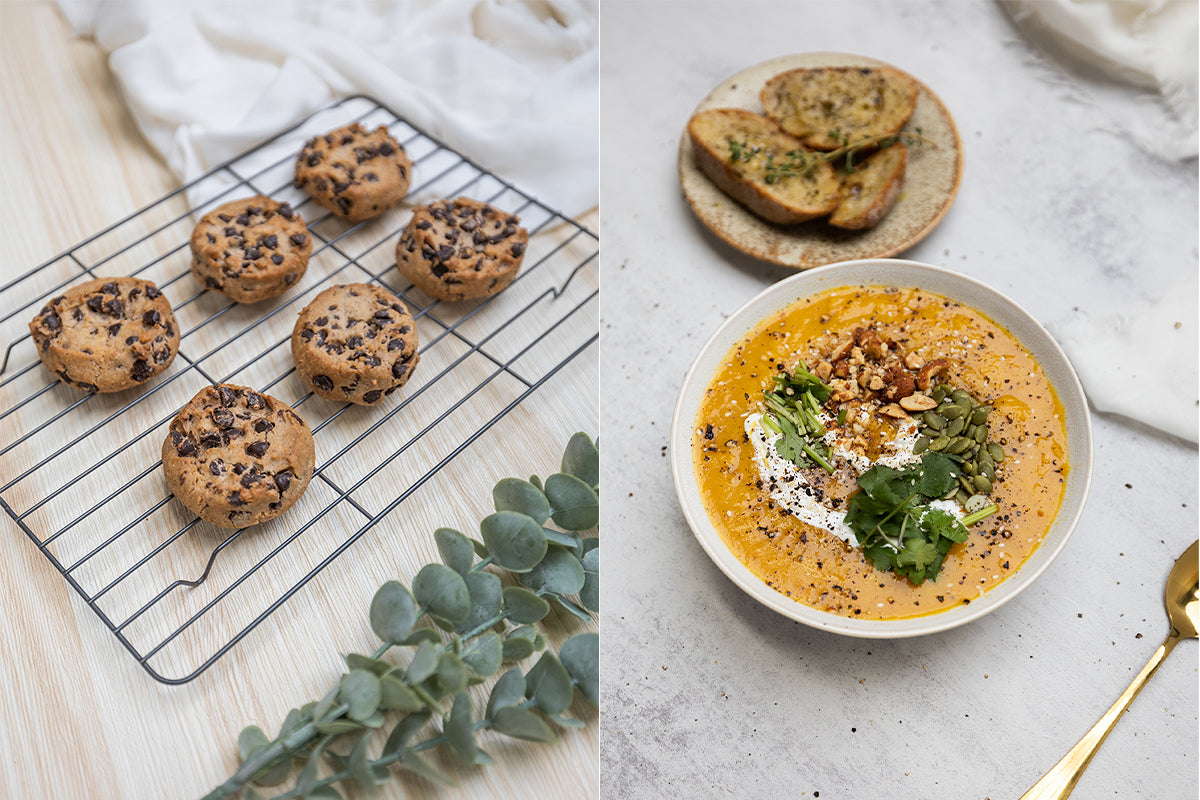 Left image: Baked cookies on wire cooling rack placed on a light wood flat lay backdrop with eucalyptus styling prop. Right image: Two plates of food, pumpkin soup and bread on a light concrete flat lay backdrop