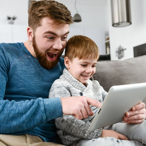 father and son looking at tablet