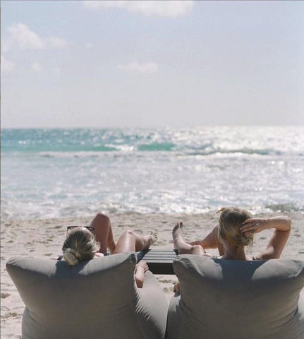 two people on soft chairs on the beach
