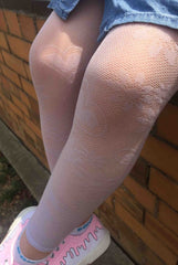 Girls sitting on a ledge with legs crossed and wearing pink sheer footless tights.