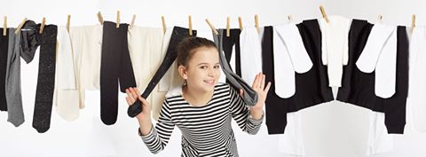 Young girl peeking out from tights pegged onto a washing line.