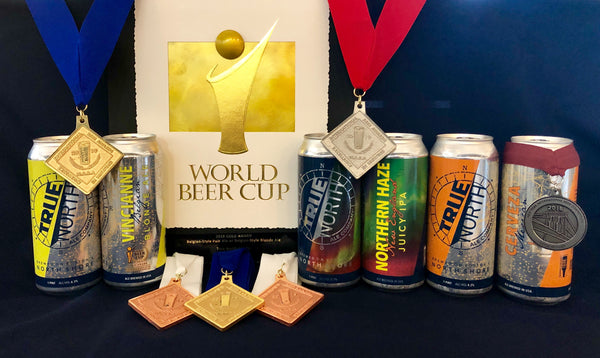 A display of awards that True North Ales has won, along with cans of the winning beers.