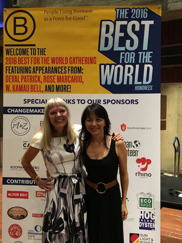 The founders of Aisle standing in from of singage that reads "The 2016 Best For The World Nominees" at a B Corp conference in 2016 