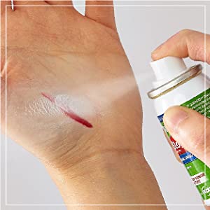 Une main applique QuickStop ! Bleeding Control Vaporisez sur une petite coupure sur la paume de l'autre main, illustrant l'application directe du produit pour arrêter le saignement.