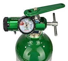 shows oxygen regulator on top of green oxygen cylinder and a green oxygen wrench.