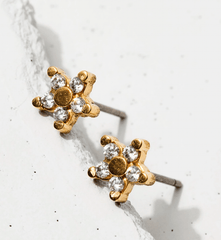 gold star shaped earrings with pave crystal detailing. the gold star earrings are laying on a white background