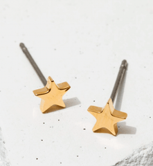 simple and dainty gold star stud earrings. star stud earrings on a white background