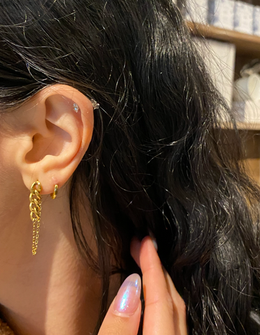 girl with 3 ear lobe piercing wearing medical grade titanium earrings 