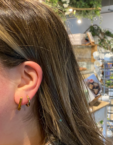 girl with 2 ear piercings wearing medical grade titanium hoop earrings
