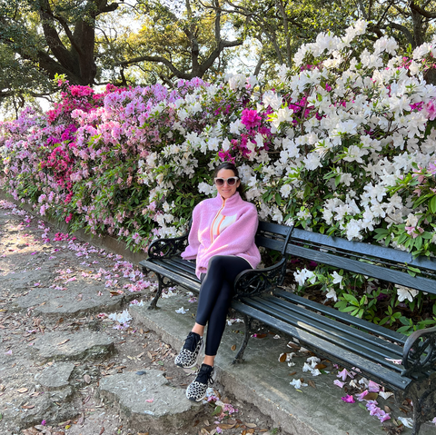 woman sitting on bench in the park with flowers