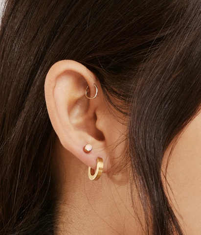girl wearing gold titanium hoop earrings for sensitive ears