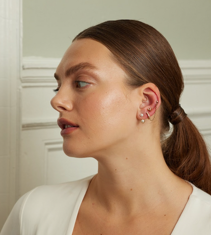 girl wearing hypoallergenic pearl earring jacket with gold ear stack